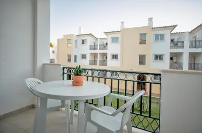 a white table and chairs on a balcony with a building at Smy Santa Eulalia Algarve in Albufeira