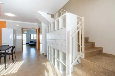 a white staircase in a living room with a table at Smy Santa Eulalia Algarve in Albufeira
