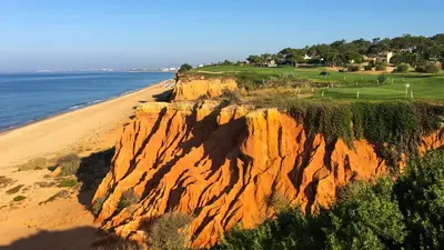 an image of a cliff next to a beach at Casa das Flores in Vale do Lobo