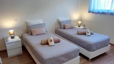 two beds in a room with two lamps on tables at Apartamento O Jardins da Marina in Albufeira