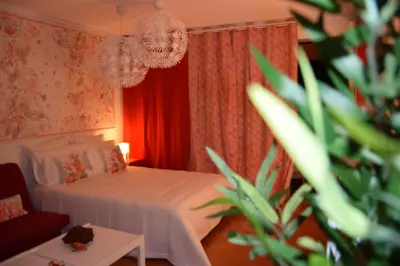 a bedroom with a white bed and a red curtain at Romantic Studio By Ethnic Ocean in Vilamoura