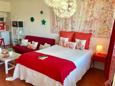 a bedroom with a red bed and a red couch at Romantic Studio By Ethnic Ocean in Vilamoura