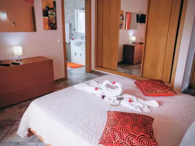 a bedroom with a bed with towels and a mirror at Vivenda Luz - Jacuzzi & Swimming Pool in Albufeira