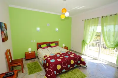a bedroom with a bed and a large window at Vivenda Luz - Jacuzzi & Swimming Pool in Albufeira