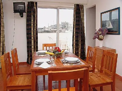a dining room with a table and chairs and a window at Apartamentos Turisticos Regina in Albufeira