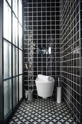 a bathroom with a toilet and a black tiled wall at Lemon Tree Stay in Faro