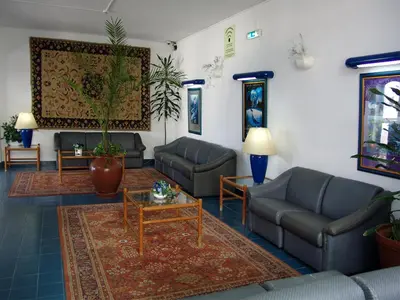 a living room with two couches and a coffee table at Hotel da Gale in Albufeira