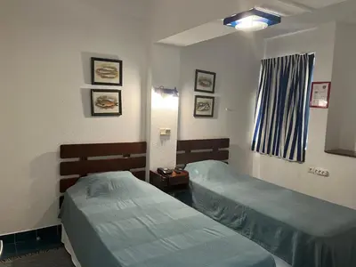 a hotel room with two beds and a window at Hotel da Gale in Albufeira