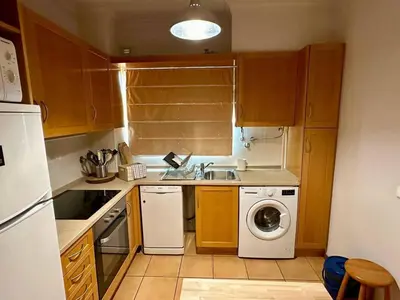 a small kitchen with a sink and a washing machine at Monteverde Kulle by FHR piscina & parking in Vilamoura