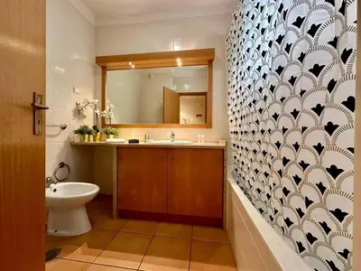 a bathroom with a sink and a toilet and a mirror at Monteverde Kulle by FHR piscina & parking in Vilamoura