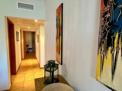 a hallway with a painting on the wall and a table at Monteverde Kulle by FHR piscina & parking in Vilamoura