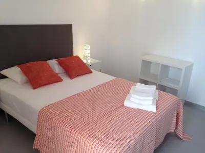 a bedroom with a bed with a red and white blanket at Casa Montechoro in Albufeira