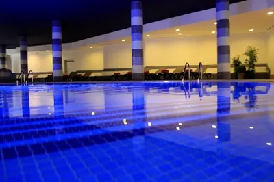 a swimming pool with blue tiles in a building at The Navigator - Solaqua in Albufeira