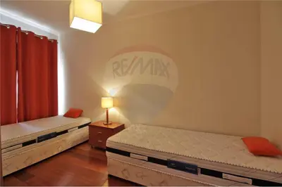 a bedroom with two beds and a sign on the wall at Corcovada, Albufeira, Algarve in Albufeira