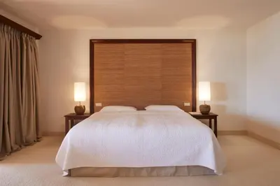 a bedroom with a large white bed with two lamps at Vila Joya in Albufeira