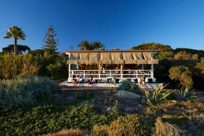 a building with people sitting outside of it at Vila Joya in Albufeira