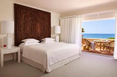 a bedroom with a bed and a view of the ocean at Vila Joya in Albufeira