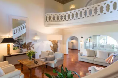 a living room with white furniture and a staircase at Vila Joya in Albufeira