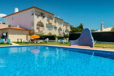 a large swimming pool in front of a house at Camilla apartment in Albufeira