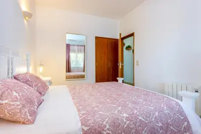 a bedroom with a large bed with pink pillows at Camilla apartment in Albufeira