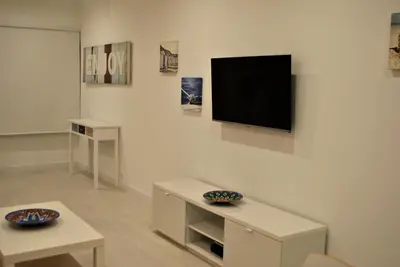 a living room with a flat screen tv on a wall at Stay Inn Albufeira - 303B Apartment in Albufeira