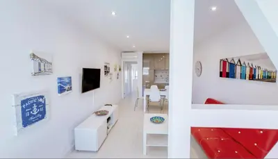 a living room with white walls and a red couch at Stay Inn Albufeira - 303B Apartment in Albufeira