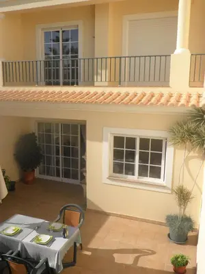 a patio with a table and a balcony at Holiday Duplex Alto dos Salgados in Albufeira