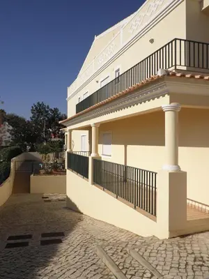 a white building with a balcony on the side at Holiday Duplex Alto dos Salgados in Albufeira
