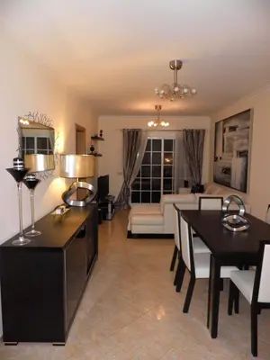 a living room with a table and a dining room at Holiday Duplex Alto dos Salgados in Albufeira