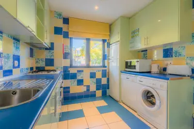 a kitchen with a washing machine and a sink at Apartamentos da Orada by Garvetur in Albufeira