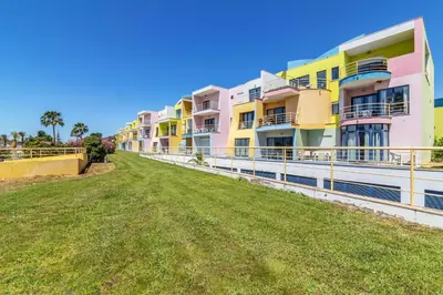 a row of colorful apartment buildings on a green field at Apartamentos da Orada by Garvetur in Albufeira