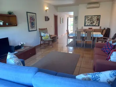a living room with a blue couch and a dining room at Apartamentos da Orada by Garvetur in Albufeira