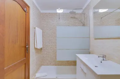 a bathroom with a sink and a toilet and a mirror at AL - Apartamento Girassol in Quarteira