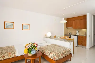 a hotel room with two beds and a kitchen at Apartamentos Edificio Albufeira - Alojamento Local in Albufeira