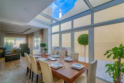 a dining room with a long wooden table and chairs at villa Aqua-Jacuzzi-heatable pool-sauna-gym-snooker in Albufeira