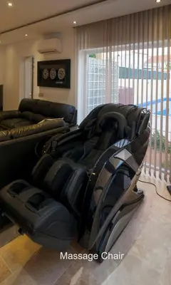 a living room with a large black couch in front of a window at villa Aqua-Jacuzzi-heatable pool-sauna-gym-snooker in Albufeira