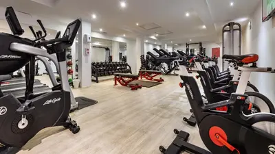 a gym with a bunch of treadms and cardio machines at The Magnolia Hotel in Quinta do Lago