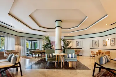 a lobby with a table and chairs at The Magnolia Hotel in Quinta do Lago