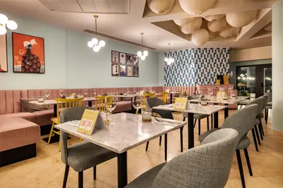 a restaurant with tables and chairs in a room at The Magnolia Hotel in Quinta do Lago