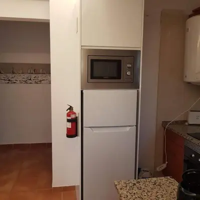 a microwave on top of a refrigerator in a kitchen at Hello Sun in Vilamoura