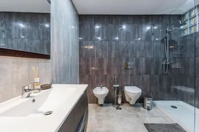 a bathroom with a sink and a toilet and a shower at Casa Laranjinha in Albufeira