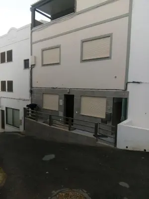 a white building with two windows and a door at Casa Laranjinha in Albufeira
