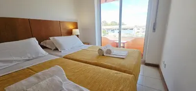 a hotel room with two beds with towels on them at Falesia Beach Apartment in Albufeira