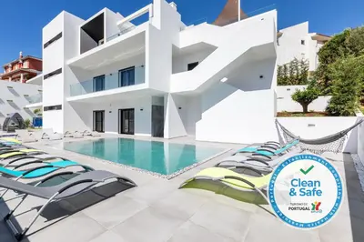 a villa with a swimming pool and lounge chairs at Luxury 47 in Albufeira