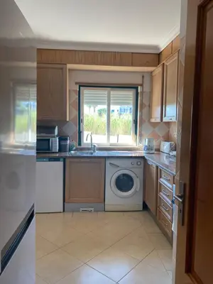 a kitchen with a sink and a washing machine at Nice apartment near Faro's airport in Faro