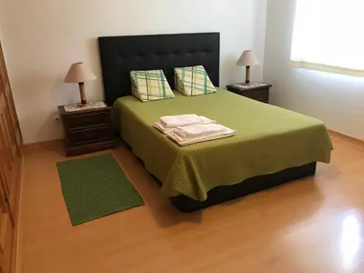 a bedroom with a green bed with two night stands at Nice apartment near Faro's airport in Faro