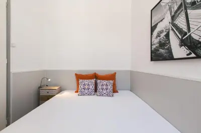 a bedroom with a white bed with two pillows at Faro Cosy Guesthouse in Faro