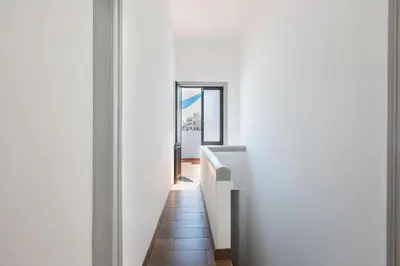 a hallway with white walls and a mirror at Faro Cosy Guesthouse in Faro
