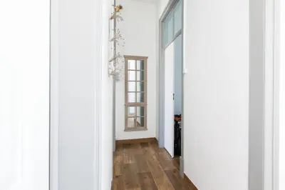 a hallway with white walls and wood floors at Faro Cosy Guesthouse in Faro