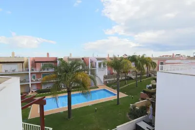 an apartment with a swimming pool and palm trees at The Old Village, Prestige and Solar by Village 4U in Vilamoura